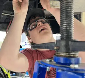 An automotive student working on the parts of a car